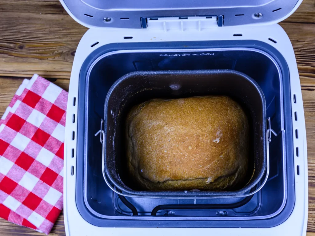 Pain de mie doré dans la cuve d’une machine à pain ouverte